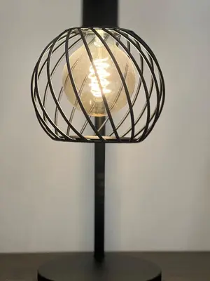 a lamp with a glass shade on a black stand at Apartment with direct access to the Sea in CTG in Cartagena de Indias