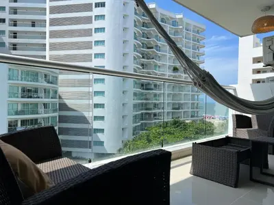 a balcony with two chairs and a large window at Apartment with direct access to the Sea in CTG in Cartagena de Indias