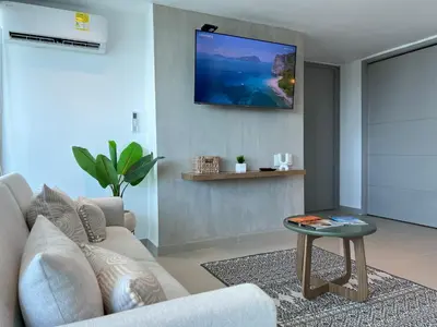 a living room with a couch and a tv on the wall at Apartment with direct access to the Sea in CTG in Cartagena de Indias