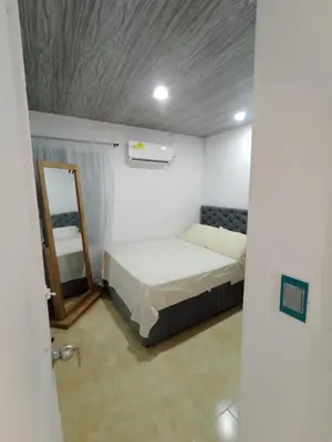 a small room with a bed and a mirror at Apto Marbella in Cartagena de Indias