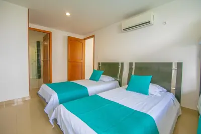 two beds sitting next to each other in a room at 2C-AL2E APARTAMENTO DE 2 ALCOCABAS CERCA AL MAR CON AIRE ACONDICIONADO, PISCINA Y WIFi in Cartagena de Indias