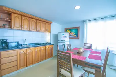 a kitchen with a table and a refrigerator at 2C-AL2E APARTAMENTO DE 2 ALCOCABAS CERCA AL MAR CON AIRE ACONDICIONADO, PISCINA Y WIFi in Cartagena de Indias
