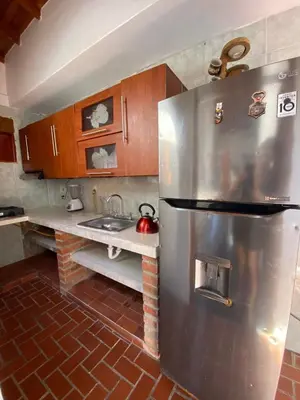 a kitchen with a stainless steel refrigerator and a sink at Cabaña Tolu in Santiago