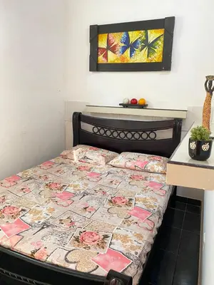 a bed with a quilt on it in a room at Cabaña Tolu in Santiago