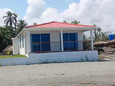 a small white house with a red roof at Hermosa Cabaña Frente Al Mar in San Bernardo del Viento