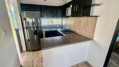 a kitchen with a stainless steel refrigerator and counter top at Hermosa Cabaña Frente Al Mar in San Bernardo del Viento