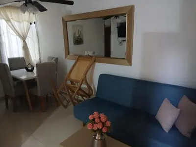 a living room with a blue couch and a mirror at Sol Serena in Soledad