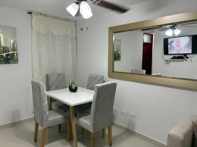 a dining room with a table and chairs and a mirror at Sol Serena in Soledad