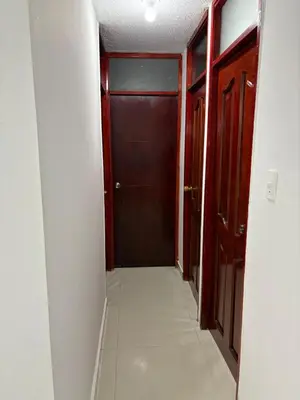 a hallway with a door and a white tile floor at Sol Serena in Soledad