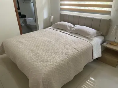 a bed with two pillows on it in a bedroom at Italia boutique Apt 2 in Barranquilla