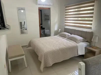 a white bedroom with a bed and a bathroom at Italia boutique Apt 2 in Barranquilla