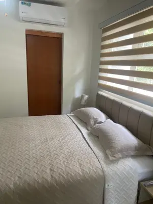 a bed with two pillows in a bedroom with a window at Italia boutique Apt 2 in Barranquilla