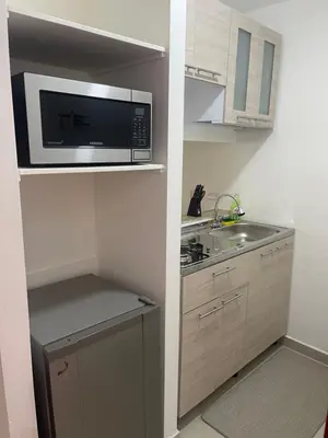 a small kitchen with a microwave and a sink at Italia boutique Apt 2 in Barranquilla