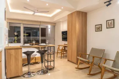 a living room with a kitchen with a bar and chairs at CB906 | Encantadora suite ocean view y diseño cálido in Cartagena de Indias