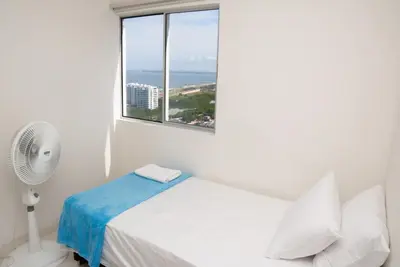 a white room with a bed and a window at Vista panoramica al Mar y Piscina in Cartagena de Indias