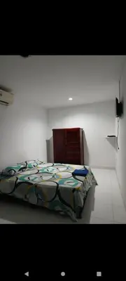 a bedroom with a bed with a colorful comforter at Hotel la Bastilla in Sincelejo