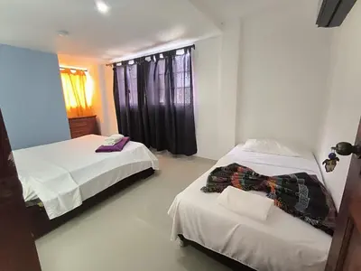 a bedroom with two beds and a window at CasaNegreteHostalBoutique in Cartagena de Indias