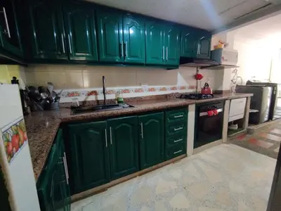 a green kitchen with green cabinets and a sink at CasaNegreteHostalBoutique in Cartagena de Indias