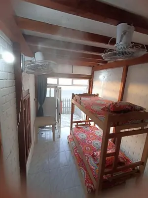 a room with two bunk beds and a table at Hostal playa descalzo in La Boquilla