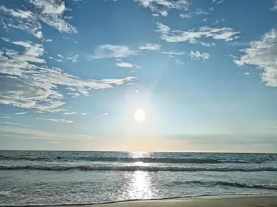 a view of the ocean with the sun setting at Hostal playa descalzo in La Boquilla