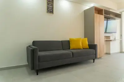 a couch with two yellow pillows in a living room at Oceanfront studio + sunset views CB1403 in Cartagena de Indias