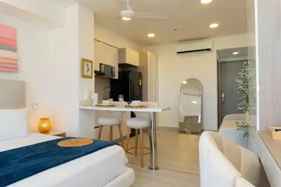 a bedroom with a bed and a table and a kitchen at CB1631 | Piso 16 con balcón y vista panorámica in Cartagena de Indias
