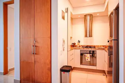 a kitchen with wooden cabinets and a stove at Dizztravel Apart H2 - 1602 Exclusivo Bocagrande in Cartagena de Indias
