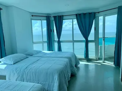 a bedroom with two beds and a large window at Tu Pent-House Con Vista al Mar! in Cartagena de Indias