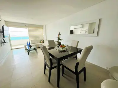 a dining room with a black table and chairs at Tu Pent-House Con Vista al Mar! in Cartagena de Indias