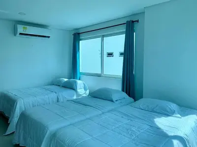 two beds in a blue room with a window at Tu Pent-House Con Vista al Mar! in Cartagena de Indias
