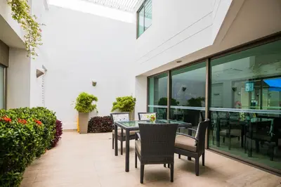 a patio with tables and chairs in a building at Varanasi Hotel Boutique Aeropuerto in Cartagena de Indias