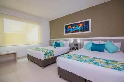 a hotel room with two beds and a window at Varanasi Hotel Boutique Aeropuerto in Cartagena de Indias