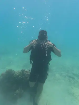 a person standing in the water taking a picture at Shekina Club House in Playa Blanca