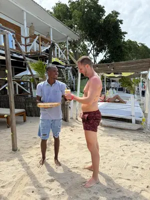 a man standing next to a man on the beach at Shekina Club House in Playa Blanca