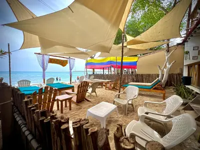 a beach with chairs and tables and umbrellas at Shekina Club House in Playa Blanca