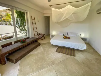a bedroom with a bed and a large window at Villa Los Cocos Baru in Baru
