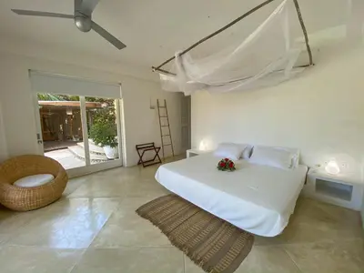 a bedroom with a white bed with flowers on it at Villa Los Cocos Baru in Baru