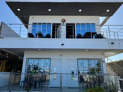 a house with a balcony with tables and chairs at Apartamentos el mochilero frente a la playa piso 1 apto 1 in Cartagena de Indias
