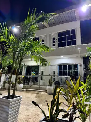 a house with a lot of plants in front of it at Apartamentos el mochilero frente a la playa piso 1 apto 1 in Cartagena de Indias