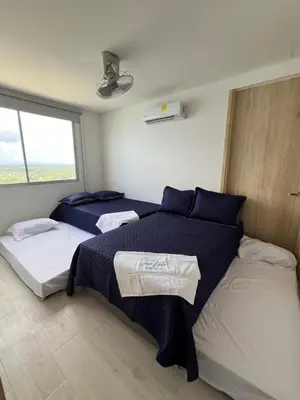 a bedroom with two beds and a window at Apartamento Torre Vela- Coveñas in Coveñas