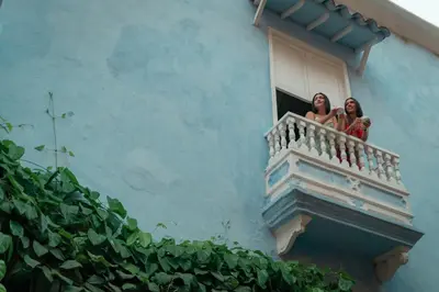 two women on a balcony of a building at Hotel Villa Alta Guest House in Cartagena de Indias