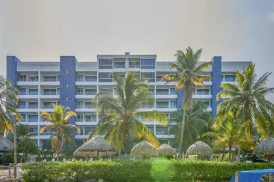 a large building with palm trees in front of it at Magico Apartamento Frente al Mar 3 Habitaciones PAZ282 in Coveñas