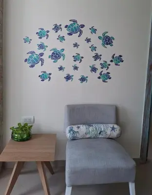 a room with a chair and a wall with turtle decals at Apartamento vacacional El Laguito Cartagena in Cartagena de Indias