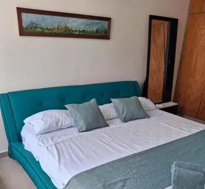 a blue bed with two pillows on top of it at Apartamento vacacional El Laguito Cartagena in Cartagena de Indias