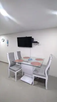 a table and two chairs and a tv on a wall at Apartamento vacacional El Laguito Cartagena in Cartagena de Indias