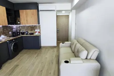 a living room with a couch and a kitchen at Aparta Suite en Cartagena de Indias in Cartagena de Indias