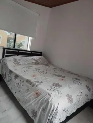 a bedroom with a bed with a floral bedspread at Habitación Caracol in Barranquilla