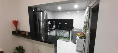 a kitchen with a black counter and a refrigerator at Habitación Caracol in Barranquilla