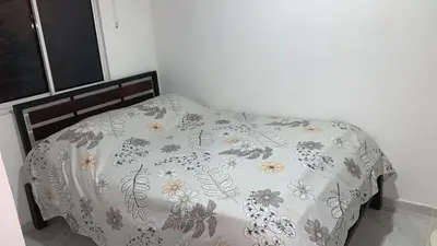 a bed with a blanket with flowers on it at Habitación Caracol in Barranquilla