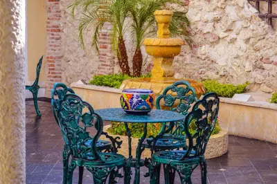 a table and chairs with a fountain in a courtyard at Hotel Boutique La Artilleria in Cartagena de Indias